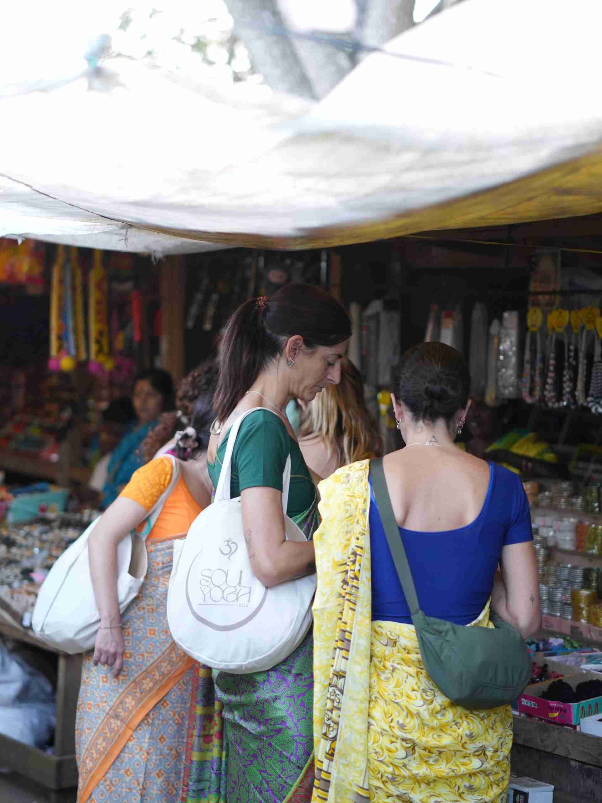 Participantes del retiro de yoga explorando un mercado local durante el viaje a India