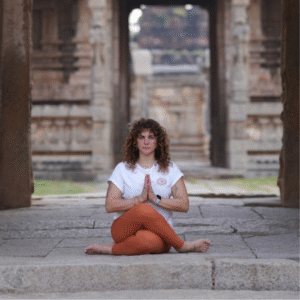 Paula Fresneda en postura de meditación durante una práctica de yoga consciente en un entorno sagrado de India