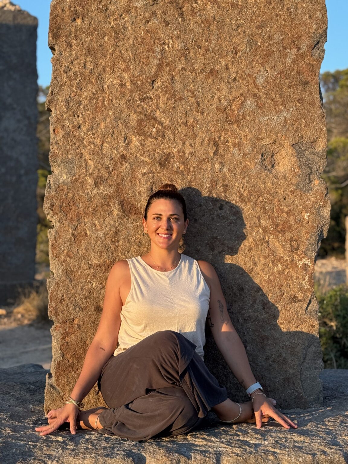 Profesora de yoga sentada en calma durante una práctica consciente al aire libre