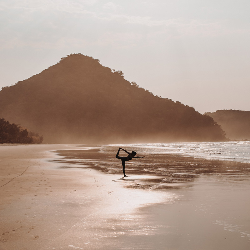 Práctica de yoga en la playa al amanecer durante un retiro