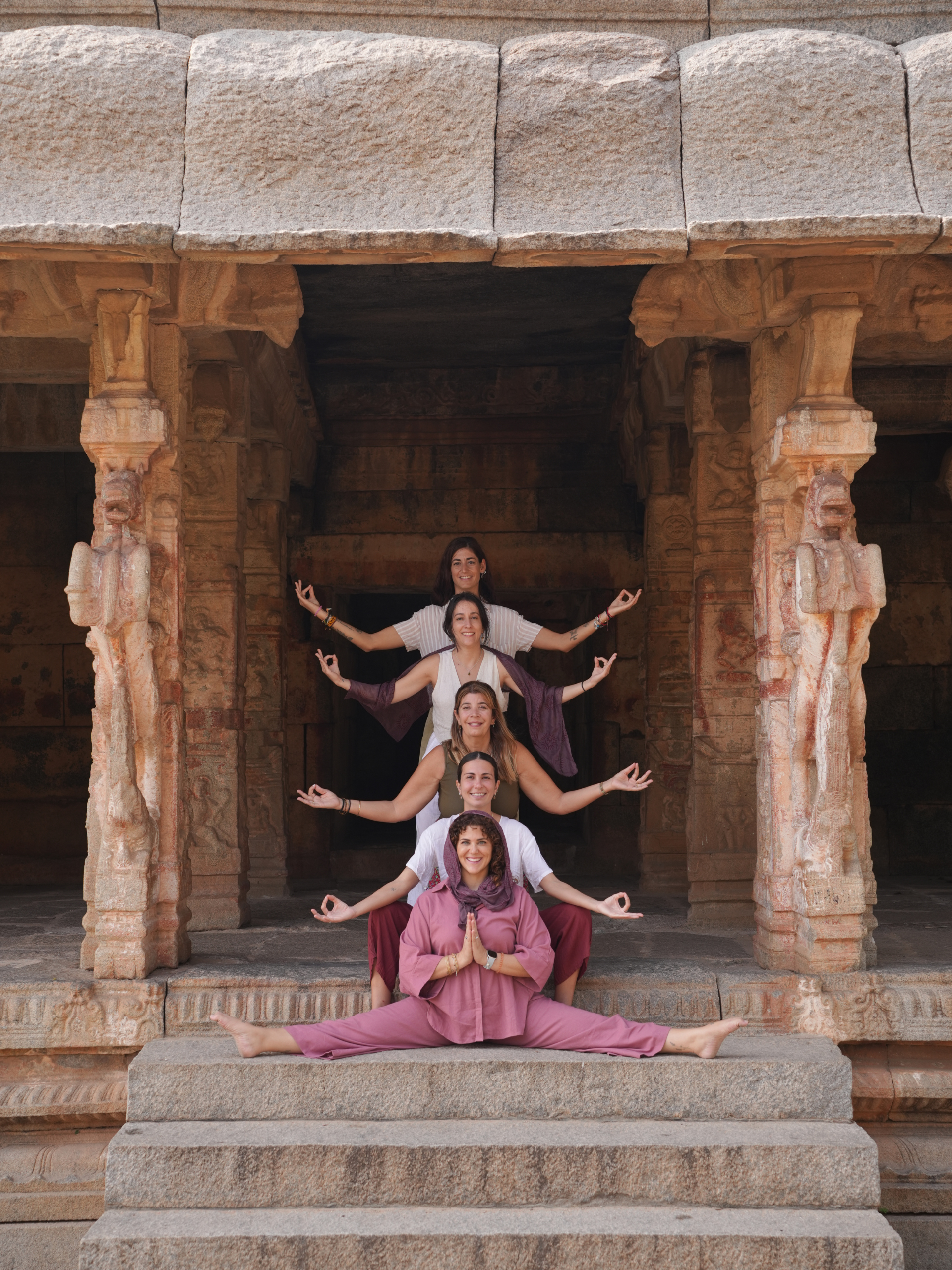 Grupo del retiro de yoga practicando en un templo sagrado de Hampi durante el viaje a India
