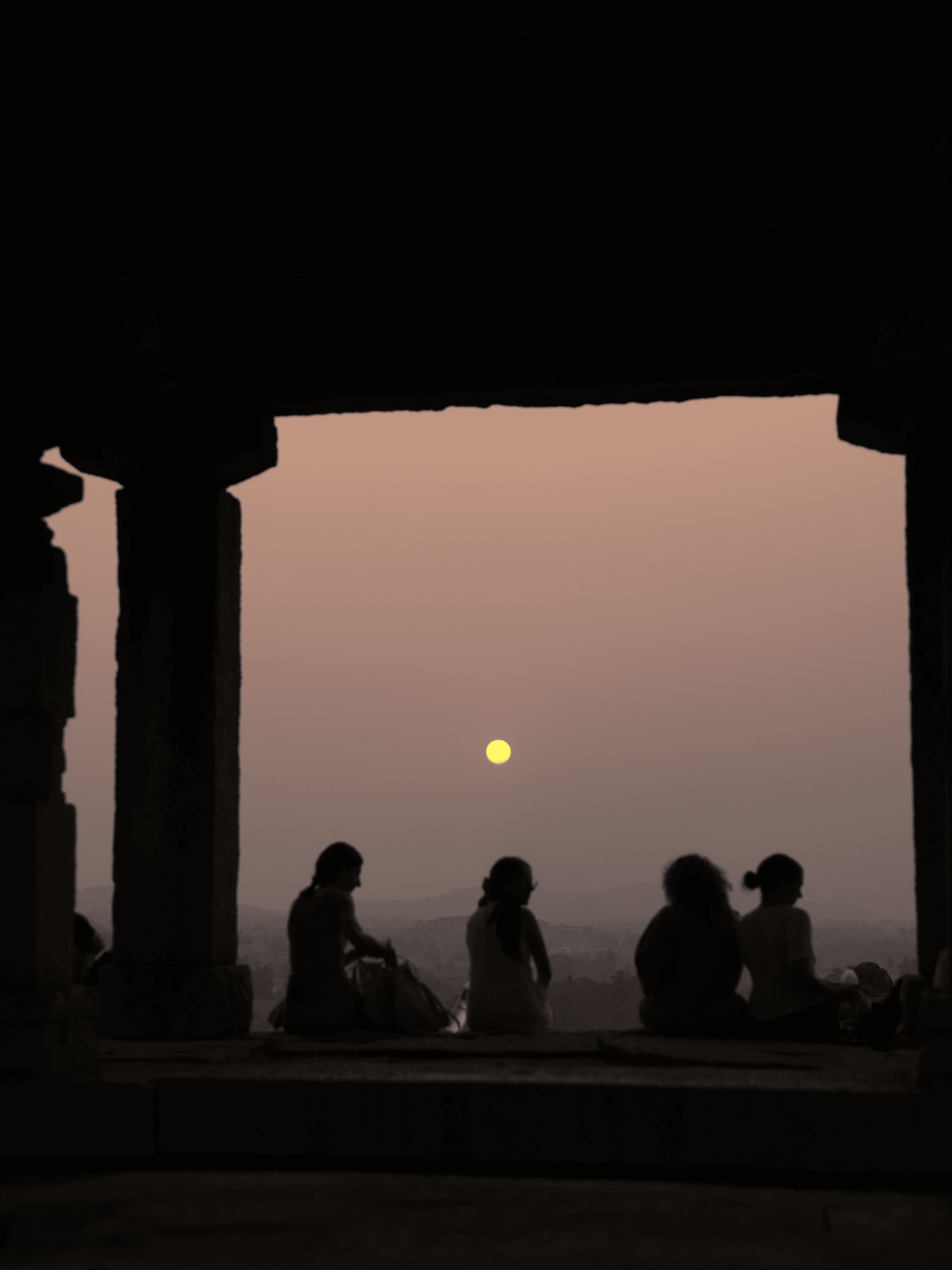 Participantes del retiro de yoga sentados en silencio al atardecer en Hampi, India