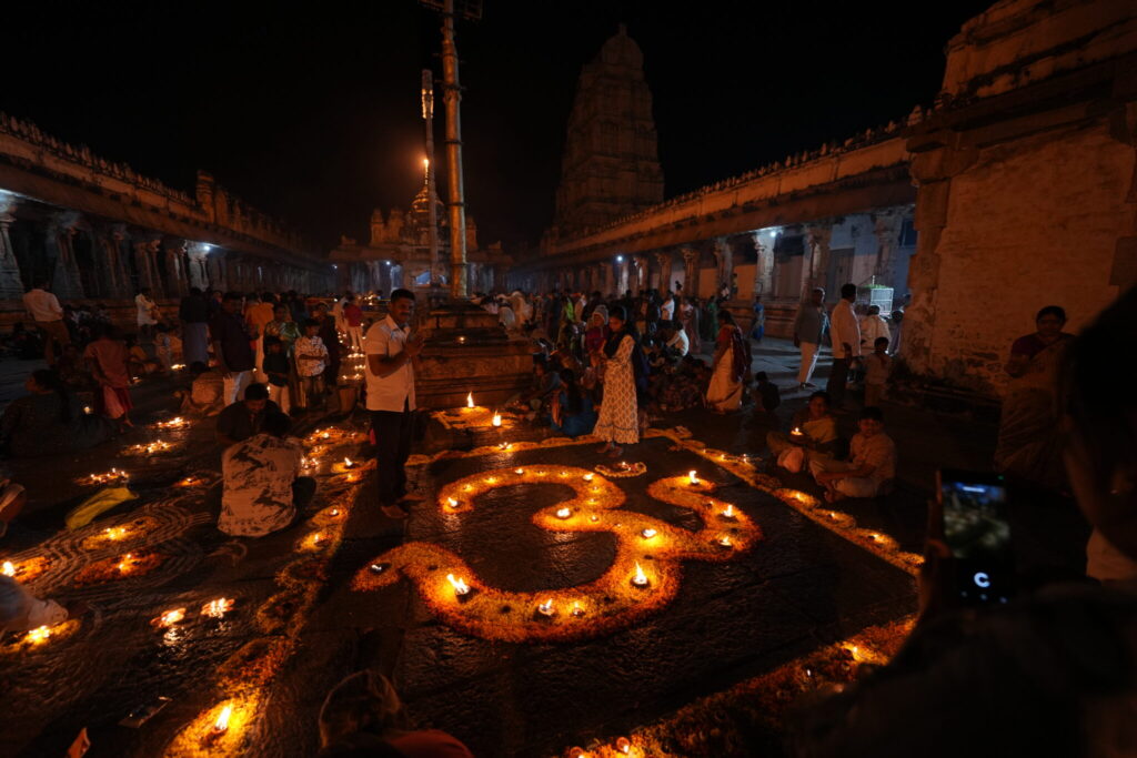 Ceremonia nocturna en el Templo Virupaksha en Hampi con el símbolo Om iluminado