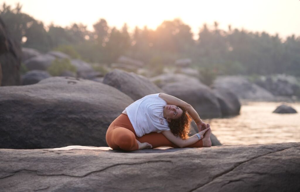 Postura de Yin Yoga en la naturaleza durante una clase del horario de clases de yoga