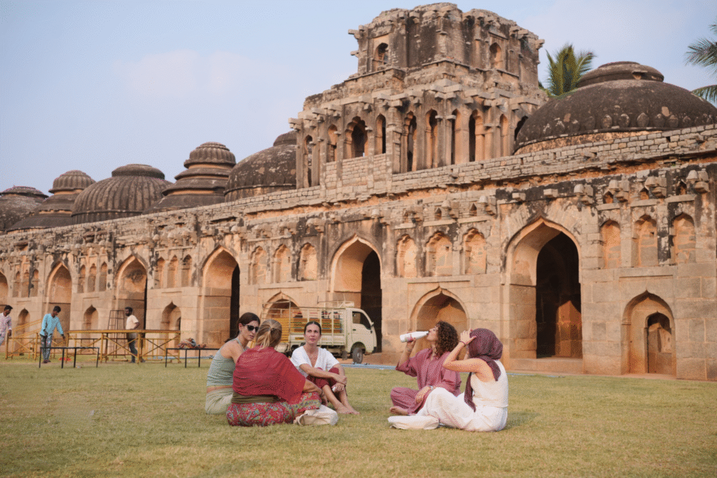 Participantes del retiro de yoga sentados frente a los Elephant Stables en Hampi