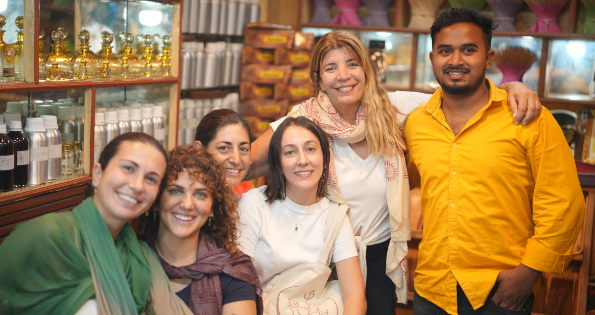 Participantes del retiro de yoga con el propietario de una tienda local en Mysore