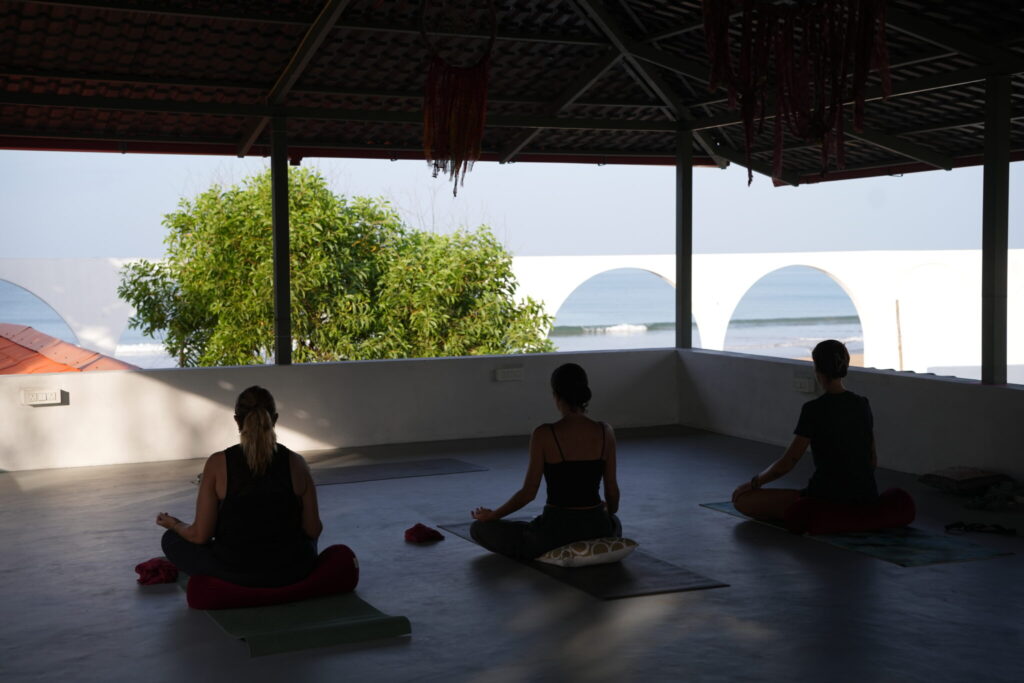 Miembros del retiro practicando yoga y meditación en la playa de Gokarna