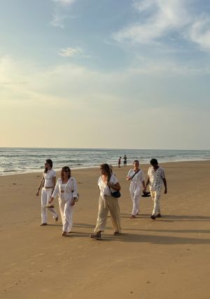 Grupo del retiro de yoga en India caminando por la playa de Gokarna frente al mar